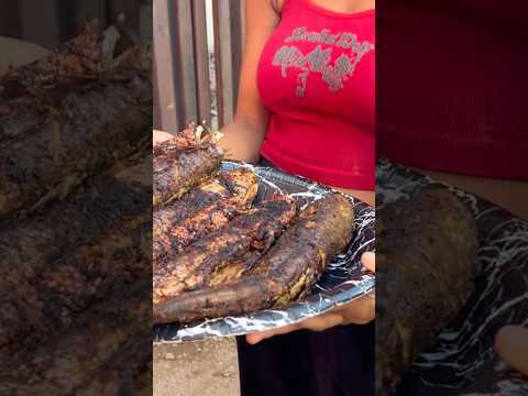 Eating grilled mullet and Mackerel fish with roasted plantain (Boli)