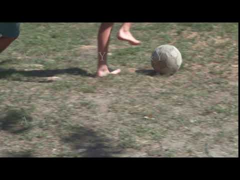 Children play football with an old ball