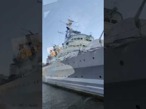 HMS Belfast battleship on the River Thames next to tower Bridge opposite tower of London