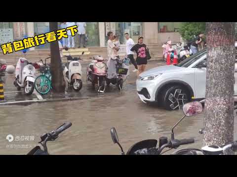 雨后的郑州中原区文化宫路与陇海西路附近，满满的积水，行人都在