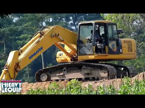 Komatsu PC200 Grading dirt and compacting dirt in a toll project