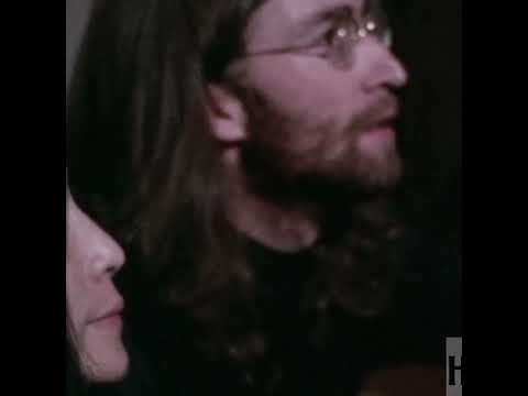 John Lennon looks at footage of himself performing at the Cavern Club in 1962.