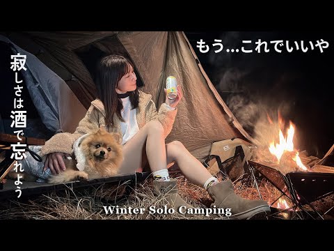 Winter camping with new goods. A woman and her dog relaxing by the bonfire