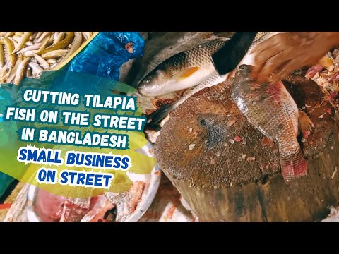 A man cutting tilapia fish on the street in Bangladesh