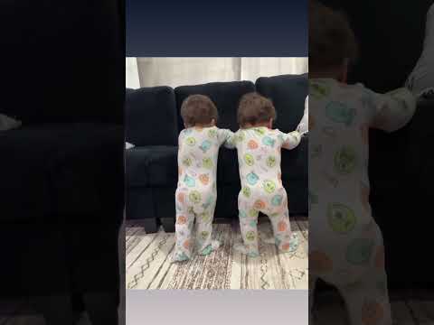 TWINS STANDING ON COUCH