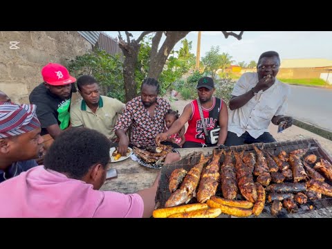 Eating grill mullet and Mackerel fish with plantain (Boli)