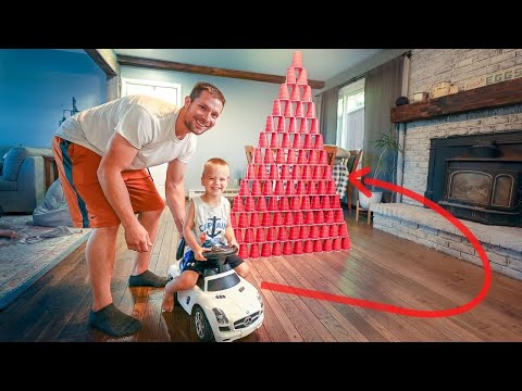 building a giant cup pyramid then Smashing through with kids toy tractor and car.