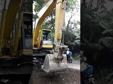 PC200 Komatsu cleaning asphalt fragments for new layer