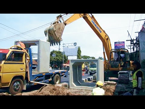 PC200 komatsu unloading concrete canal from truck on to the place