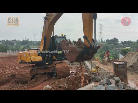 HUGE EXCAVATOR WORKING NEAR A WATER CHANNEL ON ROAD CONSTRUCTION