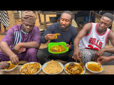 fisherwoman prepared banga soup with lot of different fish and Eba - Nigeria native soup