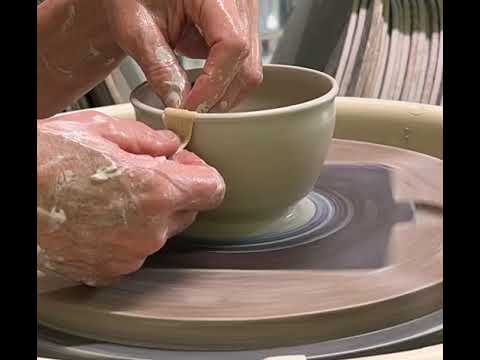 Wheel throwing a small pottery clay bowl