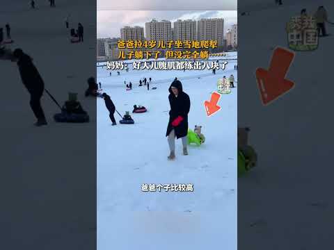 爸爸拉4岁儿子坐雪地爬犁，儿子躺下了，但没完全躺。妈妈：好大儿腹肌都练出八块了