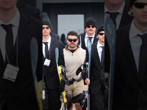 Security guards protect man snowboarding