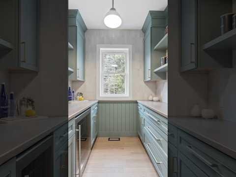 Walk-in kitchen pantry with a sliding barn door, hex tile backsplash, drink cooler, & wood counters