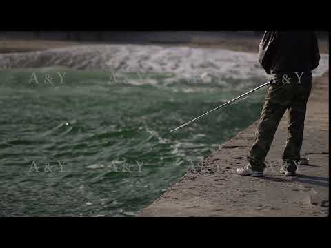 Man catches fish on the pier by the sea.