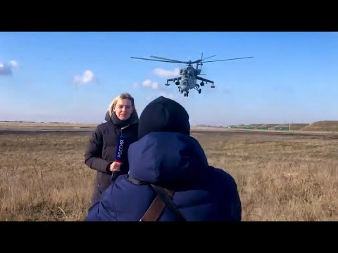 Dangerous Mi-24 Hind Attack helicopter passes over the reporter's head.