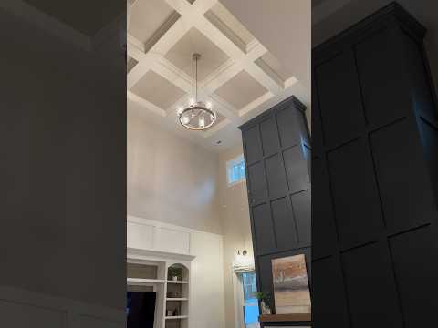 This dramatic two story fireplace and coffered ceiling are the highlights of this living room! 💕