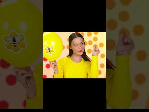 girl punctures a yellow balloon