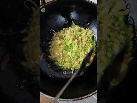 Frying onion and peas in mustard oil