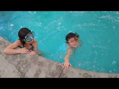 Ellie and Lucy doing backflips in the pool