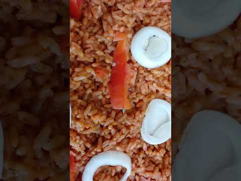 SMOKY AFRICAN JOLLOF RICE, GARNISHED WITH FRESH WHITE ONIONS & TOMATOES