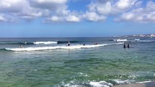 Surfers enjoy morning waves at Sunabe Seawall