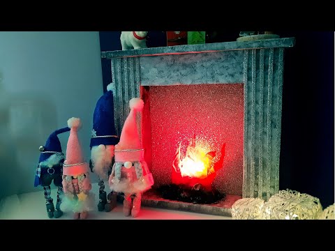 Miniature Christmas fireplace made of cardboard for decoration. New Year's holidays in a dollhouse.