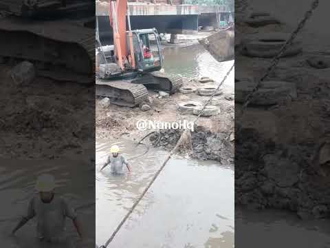 excavator hitachi pulling out big chain rope from a water