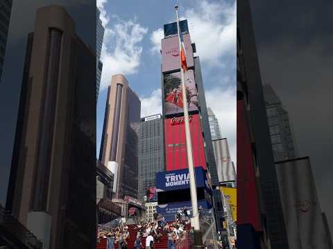 Vibrant Times Square with Father Duffy’s statue and neon signs shining bright during the day! #nyc