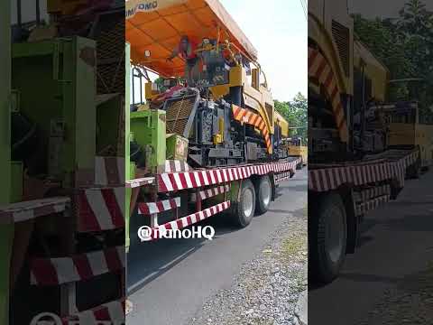 unloading paver sumitomo from self loader truck