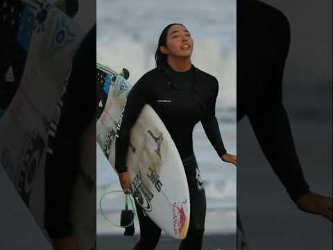 I saw a beautiful and skilled female surfer on the beach.