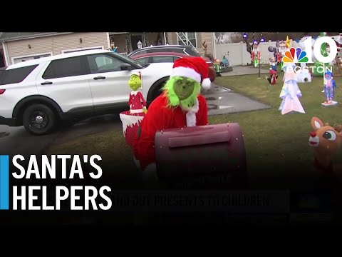 Santa's helpers hand out presents to children