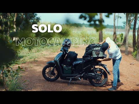 Camping alone with an electric motorbike by a large lake.