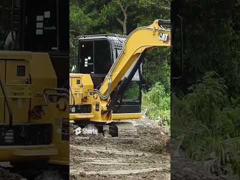 cat 305 Grading Dirt beside the water canal