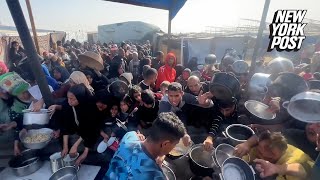 Palestinians in Gaza wait in lines to get food