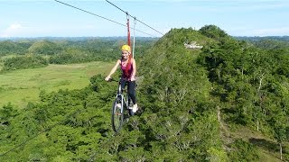 Tourists Ride Bicycle Over Zipline