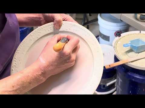 Glazing a wheel-thrown slip trailed pottery plate. Finished result is at the end of the video.