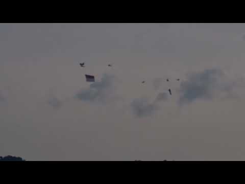 NDP 2022-  Chinook assembling in the air carrying the Singapore Flag with flypast