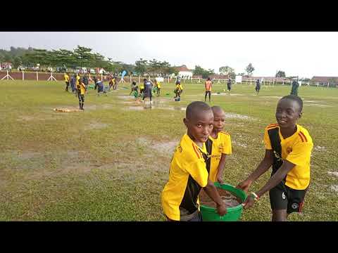 Amazing Gaddafi FC team work as they are trying to remove water from the pitch after heavy downpours