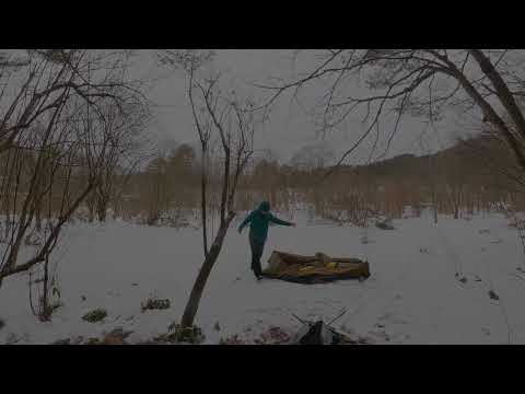 Snow tent camping in warm winter forest